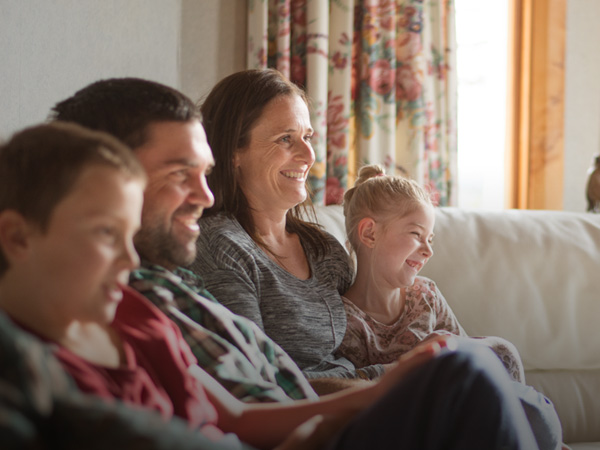 A family sitting down in a lounge and smiling